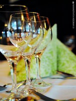 Una hilera de copas de vino vacías sobre una mesa con un servilleta de estampado verde.