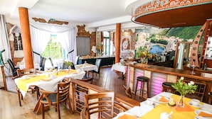 A restaurant with wooden tables, chairs, and a bar area. - Backstage Hotel (Dresden)
