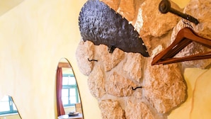A stone wall with a wooden chair and a coat rack. - Backstage Hotel (Dresden)