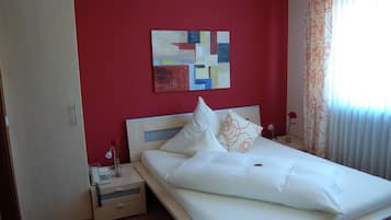Une chambre d’hôtel avec un lit, une table de chevet, un téléphone et un tableau au mur.