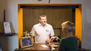 A reception desk with a wooden frame, a sign above it reading "Reception", and a framed picture on the counter.