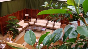 A spacious indoor seating area with wicker furniture and large green plants. - Hotel Torres Touriño (Sanxenxo)