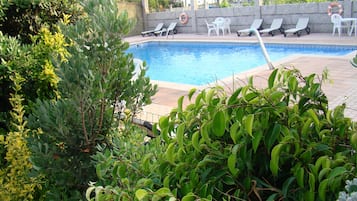 Alberca al aire libre por temporada y sombrillas en la alberca