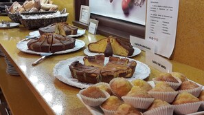 Una barra de buffet con diversas opciones de repostería, incluyendo pasteles y muffins.