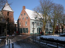 Un bâtiment historique doté d’un toit à forte pente et d’une tour en briques.