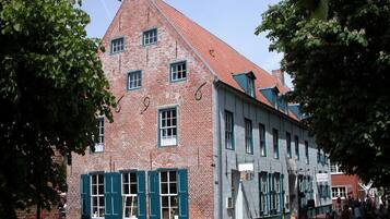 Ein historisches Backsteingebäude mit zahlreichen Fenstern und einem roten Ziegeldach.