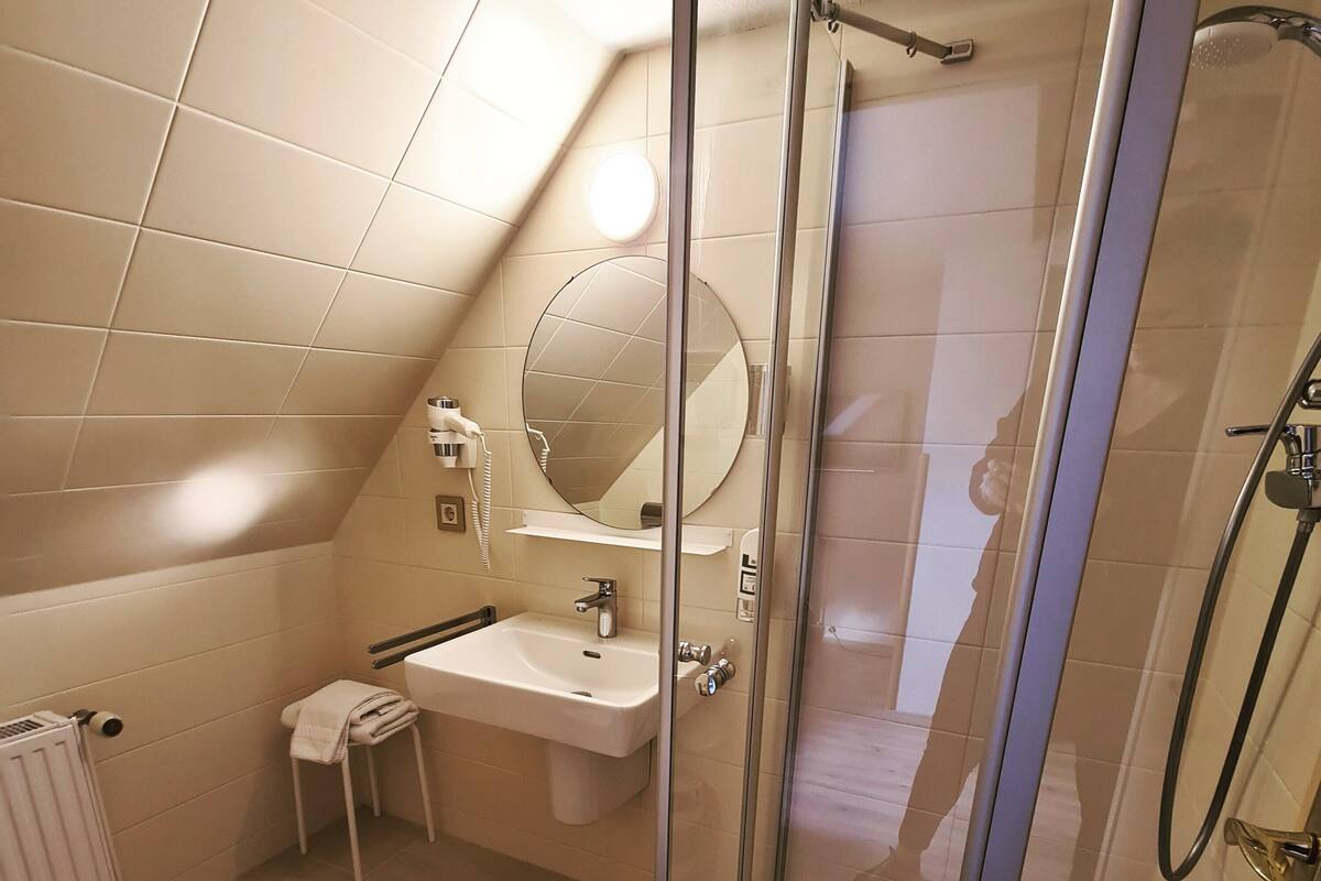 Une salle de bain moderne avec une douche à parois de verre, un lavabo blanc et des toilettes.