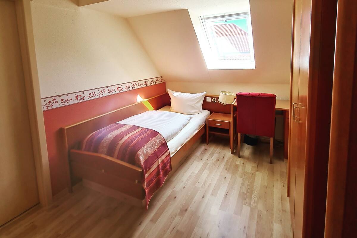 Une chambre à coucher avec un lit, un bureau et une chaise.