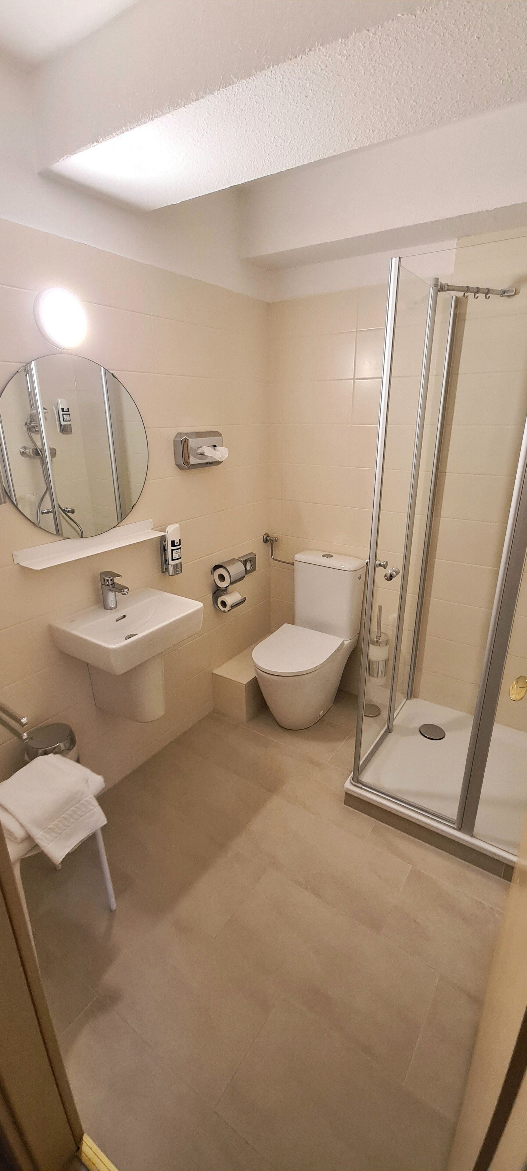 A modern bathroom with a sink, toilet, and glass-enclosed shower.