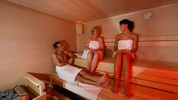 Un sauna avec des bancs en bois et un appareil de chauffage visible.
