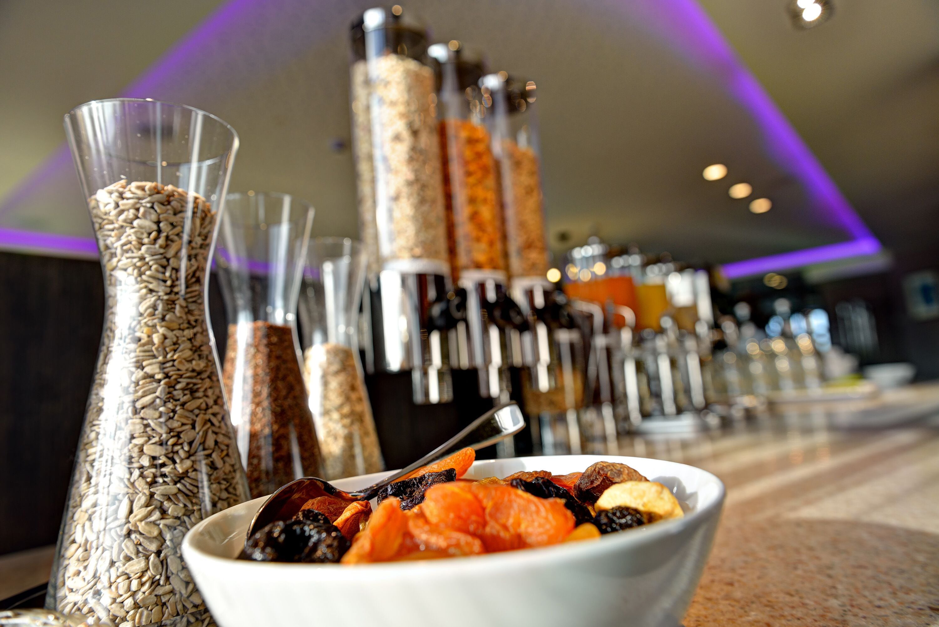 Buffet com diversos alimentos e acompanhamentos em recipientes transparentes.