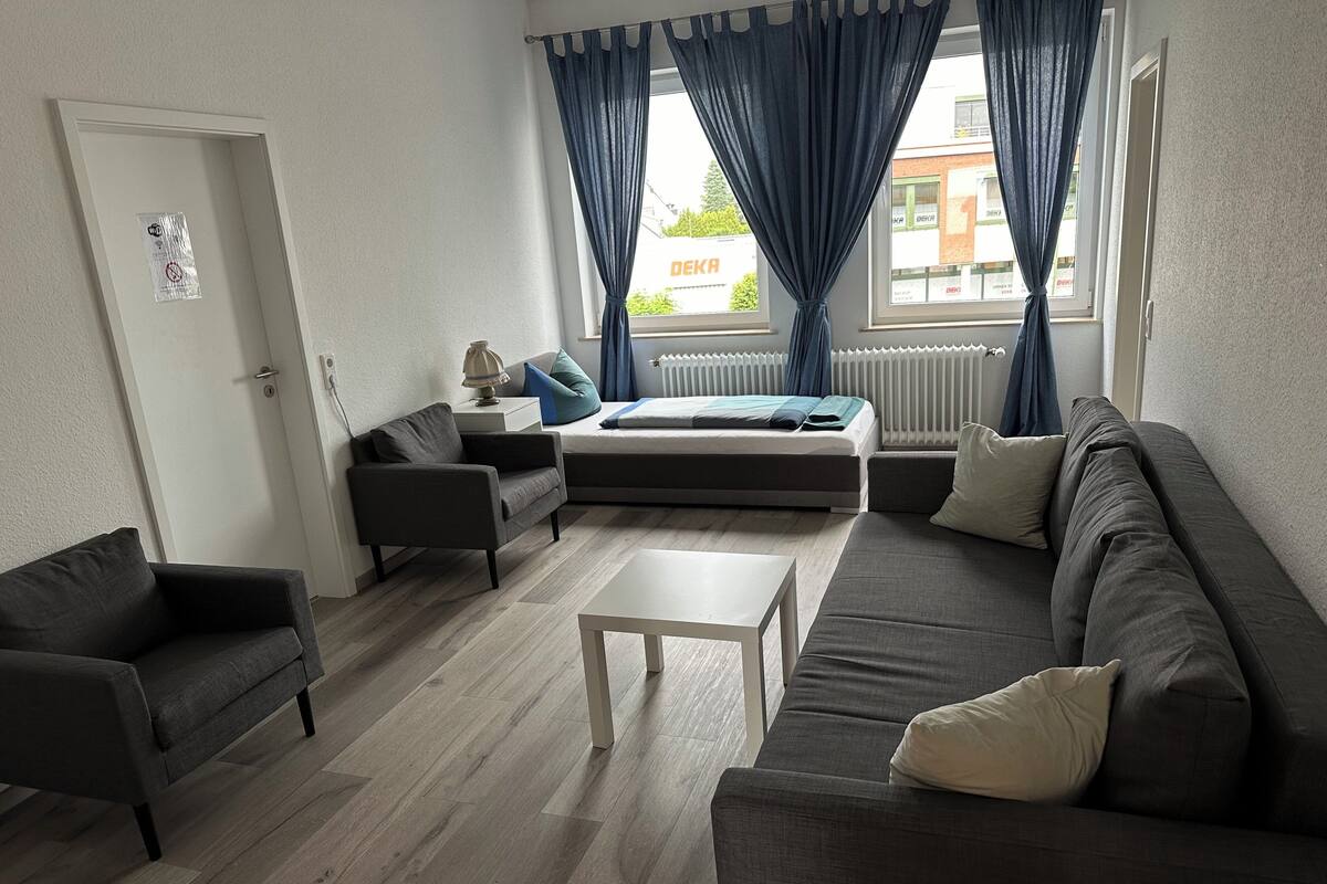 A modern living room with a sofa, armchair, and a small table.