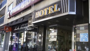 A hotel named 'Hotel de Reyes Catolicos' with a prominent sign, large windows, and a visible 'HR' sign on the door. - Hotel Reyes Catolicos (Salamanca)