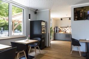 Una cocina moderna con un refrigerador grande, armarios de madera y una encimera con cafetera.