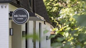 A building with a sign that reads "mk hotels ESCHBORN". - mk | hotel eschborn (Eschborn)