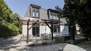 A modern house with a patio area, outdoor seating, and a pergola. - mk | hotel eschborn (Eschborn)