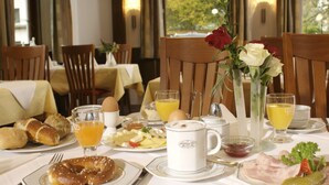 A breakfast setting with bread, pastries, eggs, and beverages on a table. - Hotel Gasthof Seefelder Hof (Dießen am Ammersee)