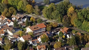 An aerial view of a marina with numerous boats docked, surrounded by residential buildings and a pier extending into the water. - Hotel Gasthof Seefelder Hof (Dießen am Ammersee)