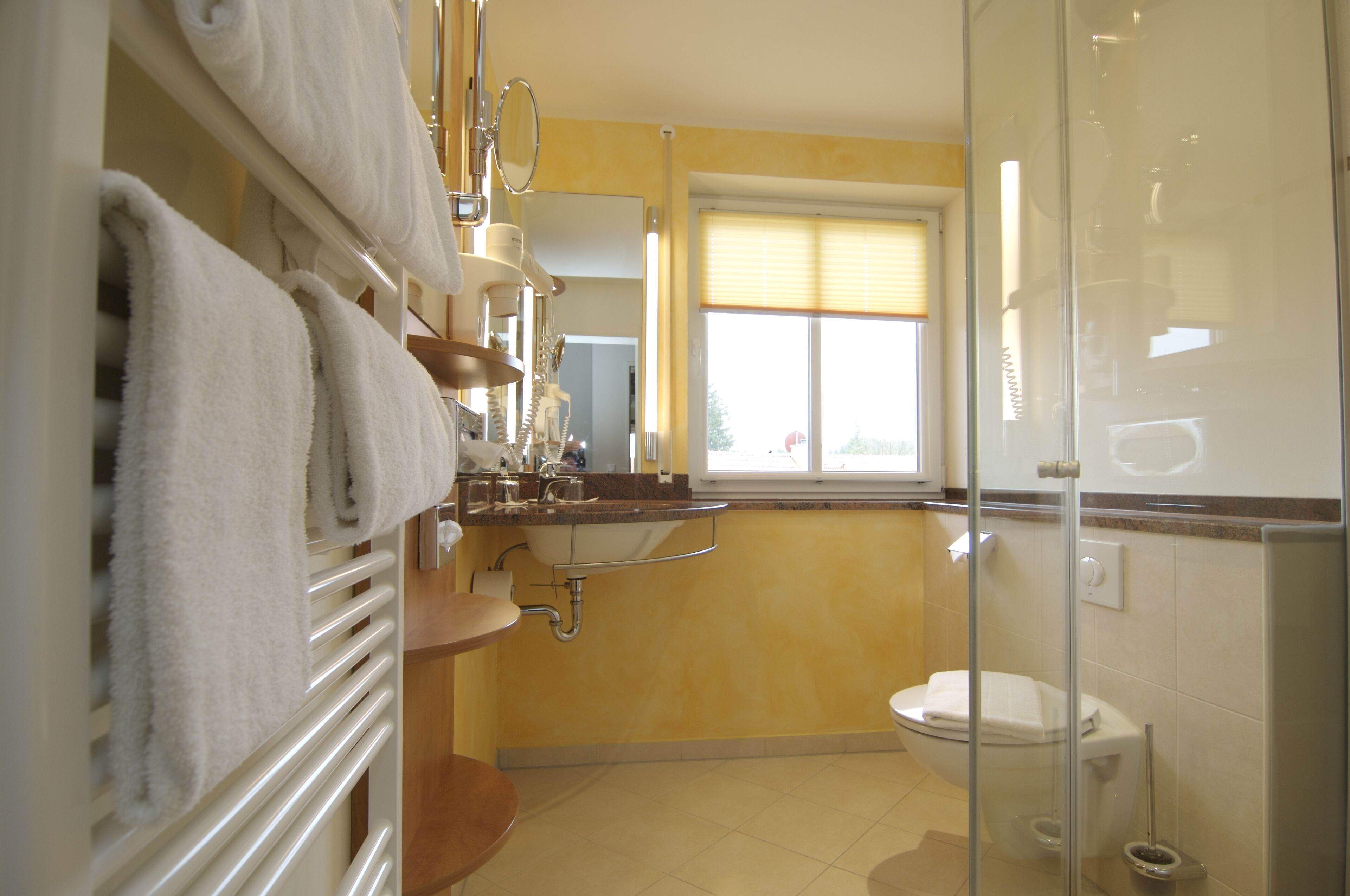 A bathroom with a toilet, sink, and towel rack.