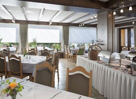 Un restaurante con varias mesas, sillas y una zona de bufé.