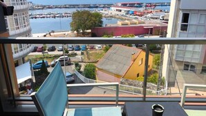 Ein Balkon mit Blick auf einen Hafen, Gebäude und einen klaren Himmel.