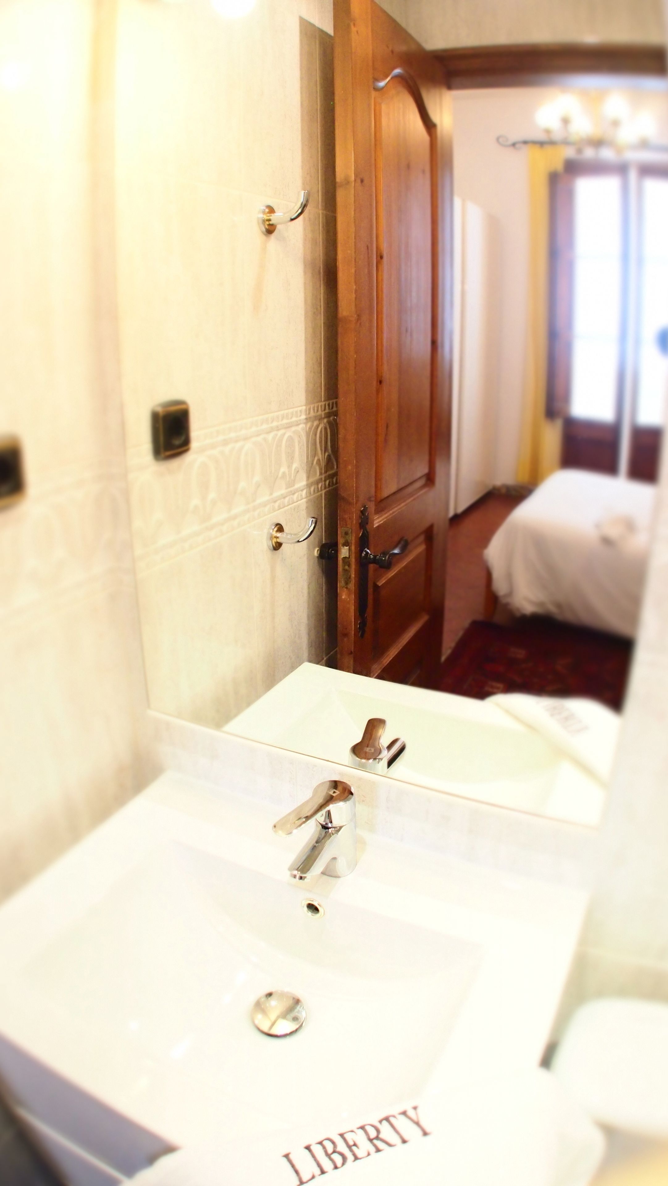 A bathroom with a sink, mirror, and wooden door.