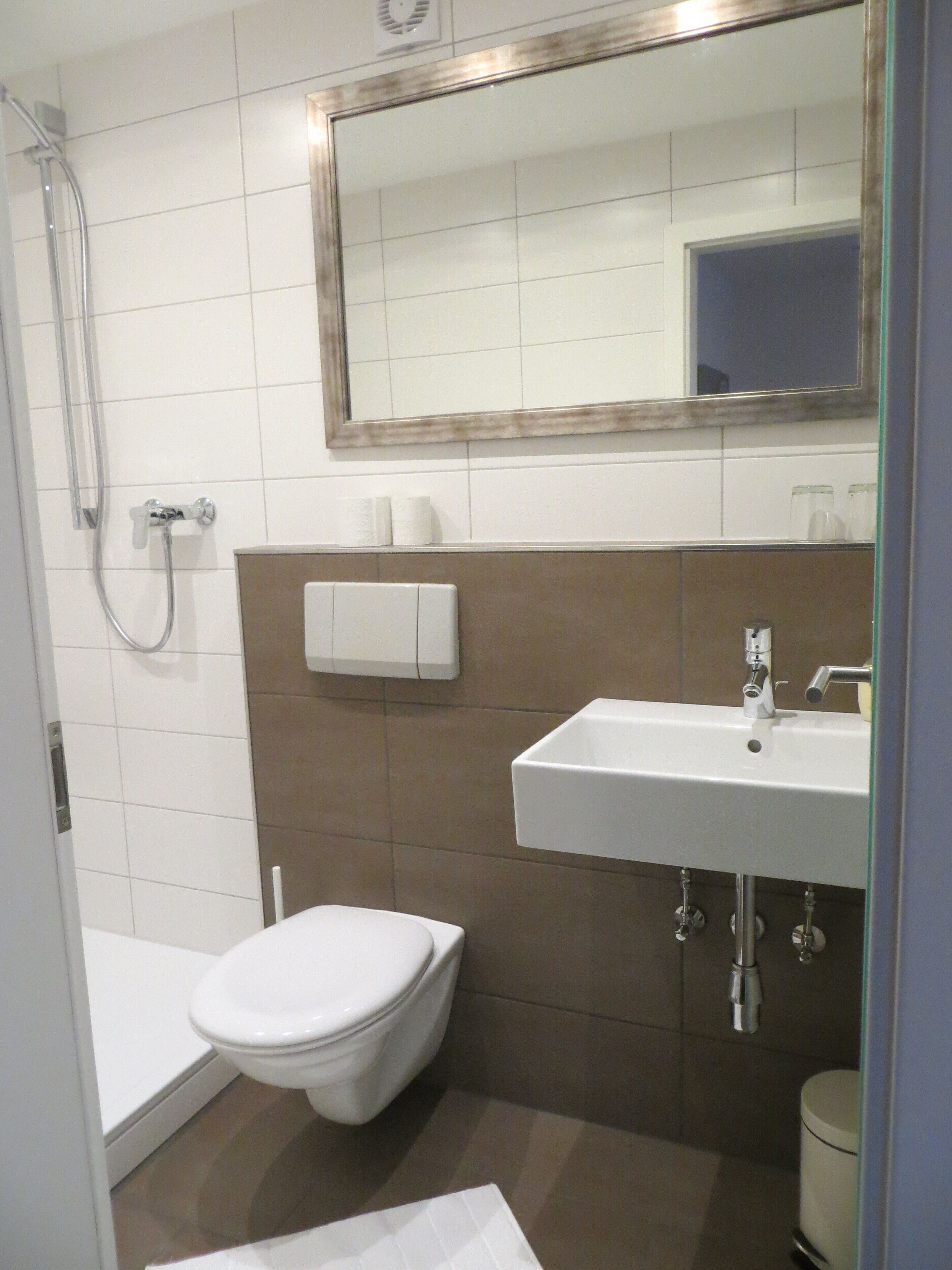 A bathroom with a toilet, sink, and shower.