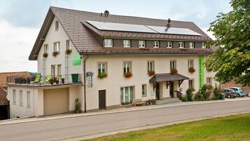 Un bâtiment à deux étages, doté d’un toit en pente, de nombreuses fenêtres et d’un espace d’entrée abrité.