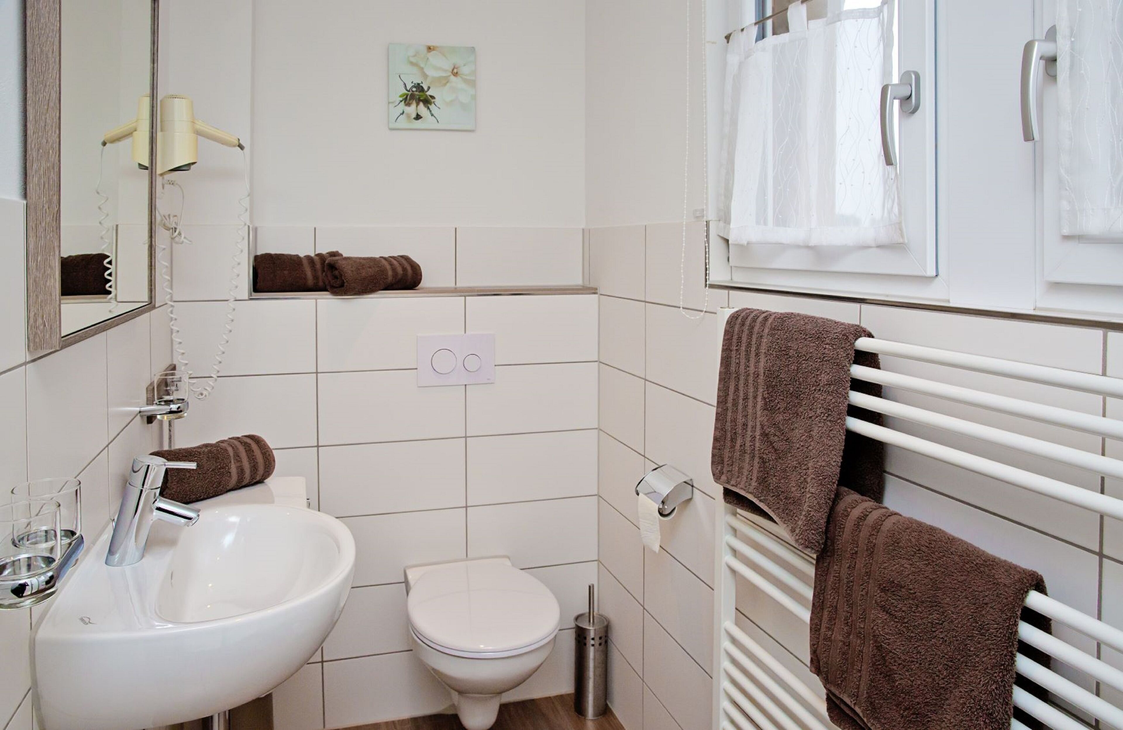 Un baño con lavamanos, inodoro y perchero.