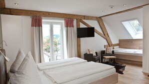 A bedroom with a bed, a desk, a chair, and a TV. - Pension Kramer (Grafenhausen)