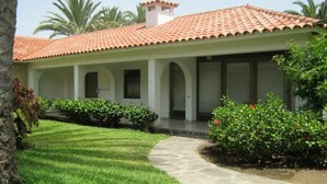 A building with a tiled roof, a covered patio area, and a stone pathway leading to the entrance. - Sun Club Premium (San Bartolome de Tirajana)