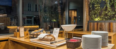 A wooden counter with bread, plates, and a menu.