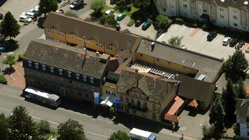 An aerial view of a residential area with multi-story buildings, parked cars, and a bus.