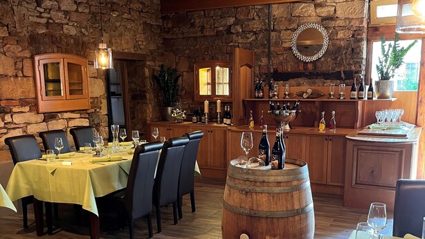 Een restaurant met een stenen muur, houten kasten en een bar.