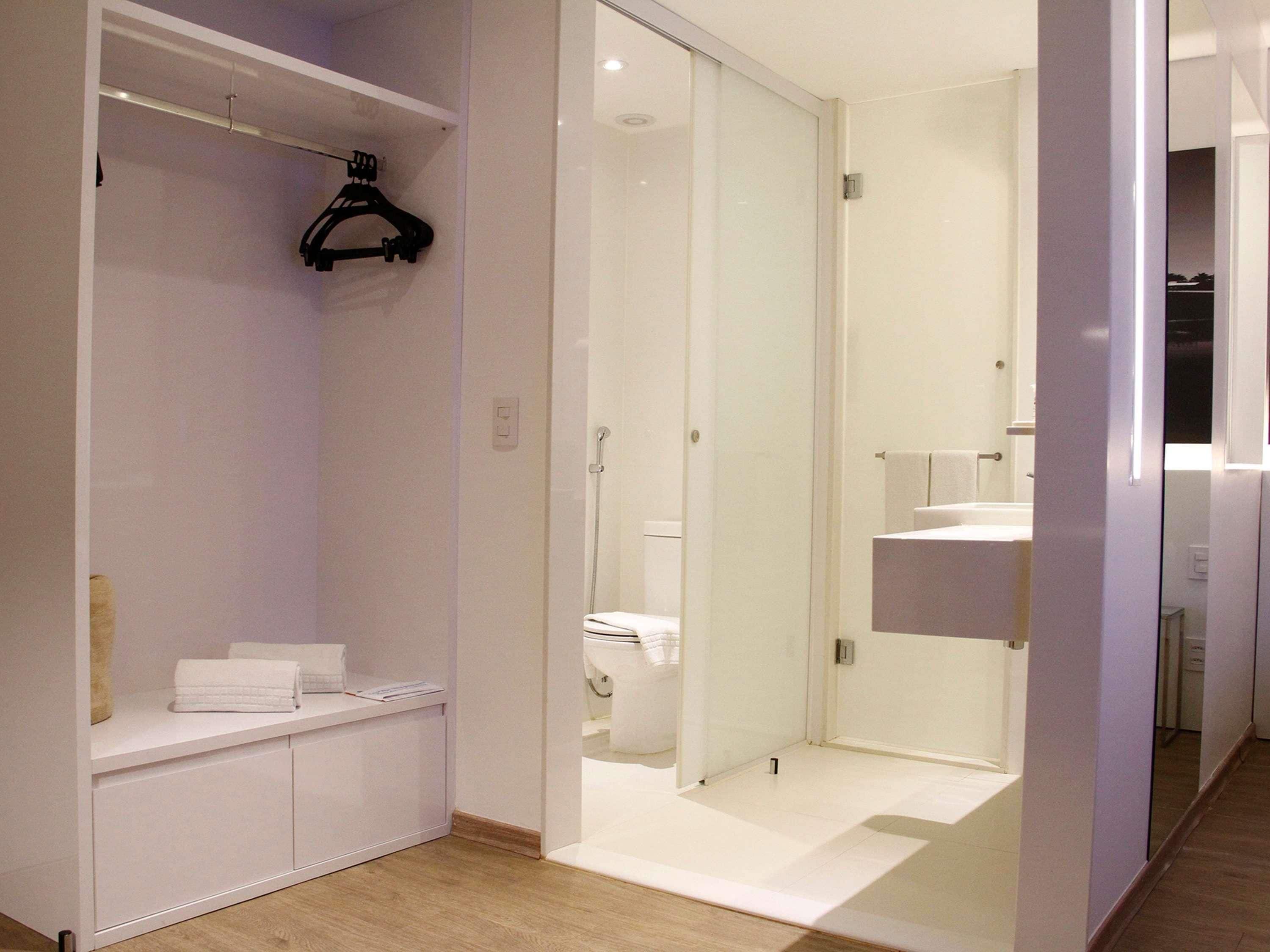 Ein modernes Badezimmer mit bodengleicher Dusche, Toilette und Waschbecken.