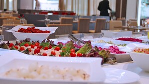 Een buffet met diverse gerechten en een persoon op de achtergrond.