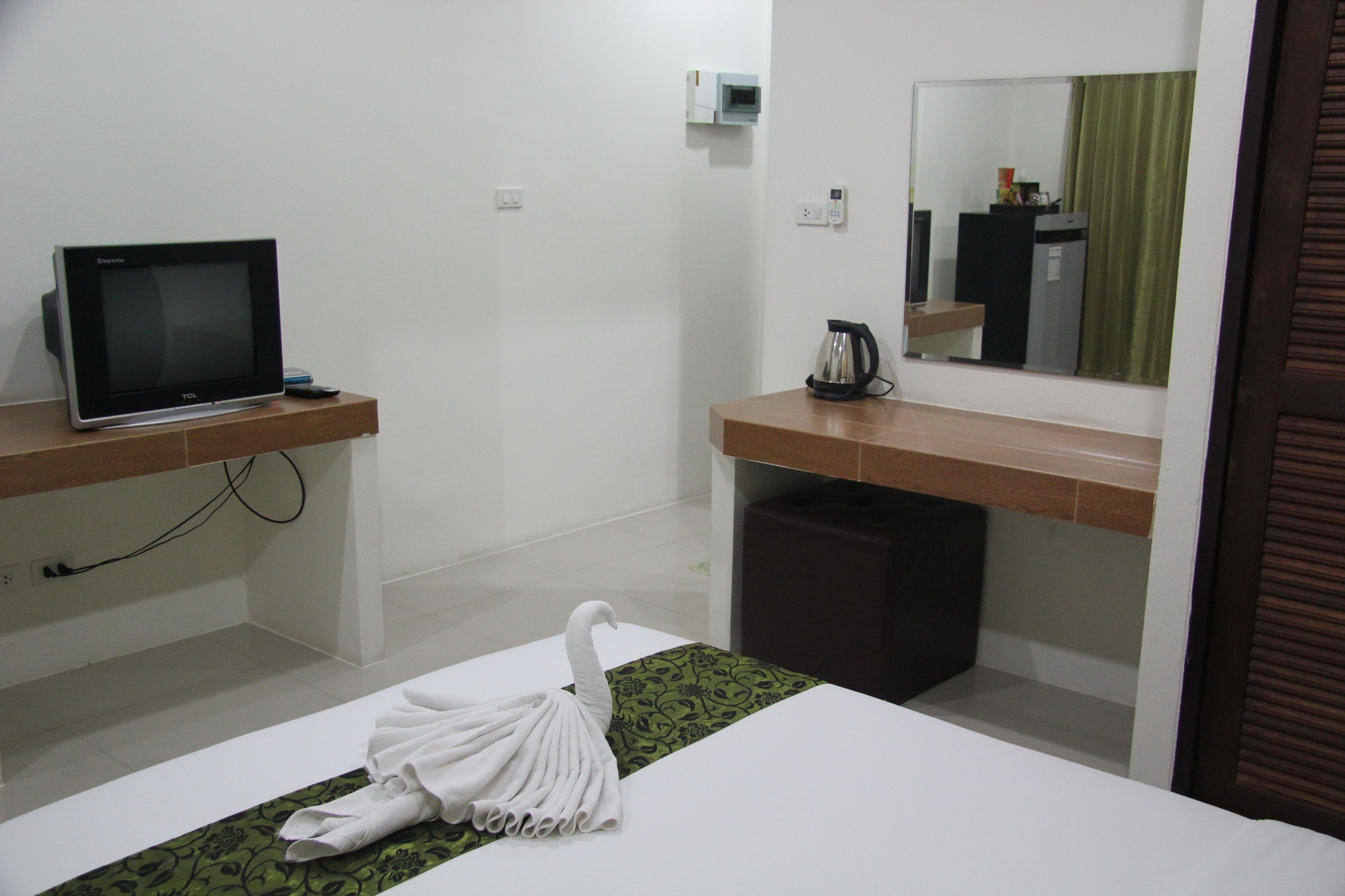 Une chambre d’hôtel équipée d’un lit, d’une télévision, d’une machine à café et d’un miroir.