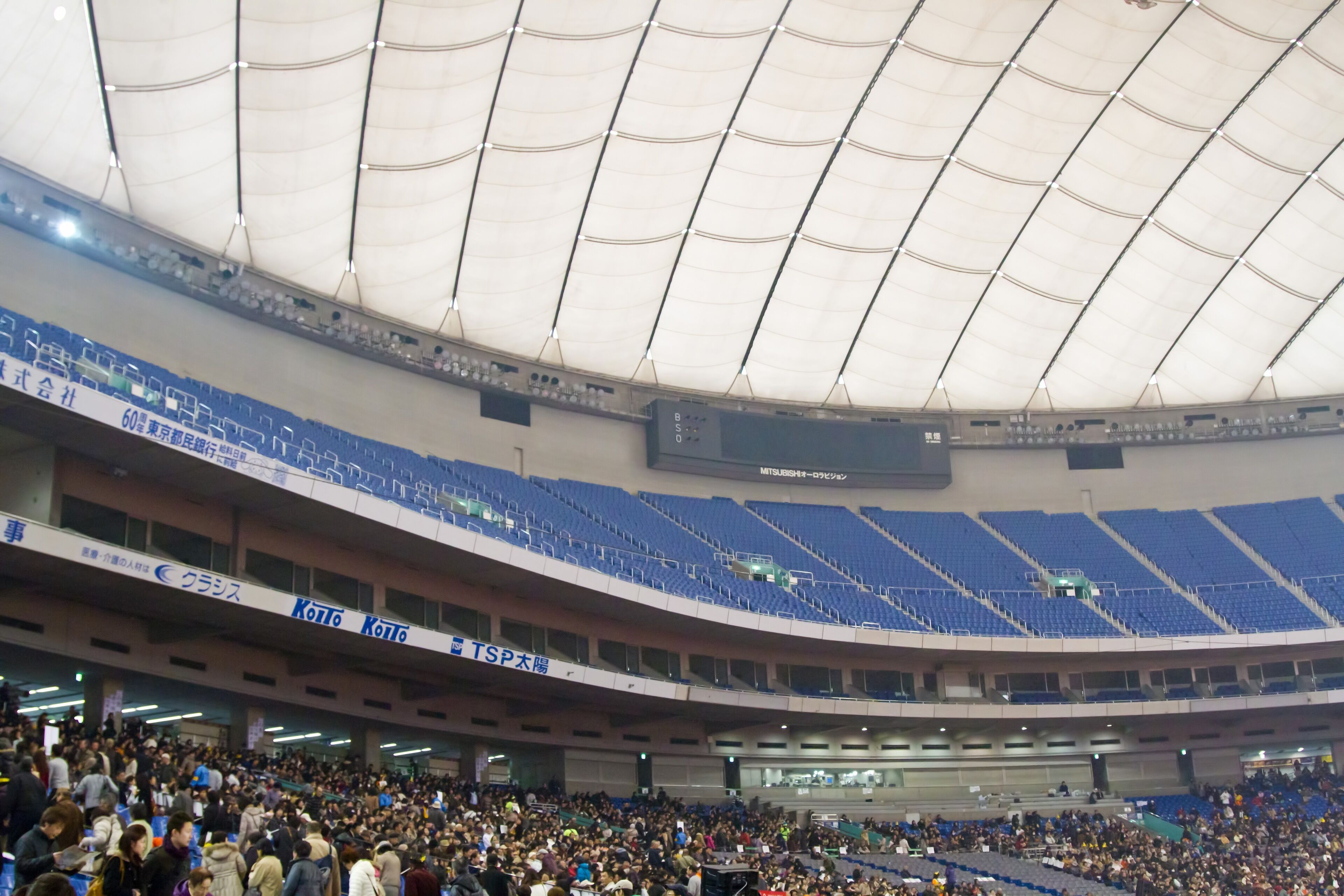 A large indoor stadium with multiple tiers of seating and a high ceiling.