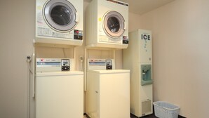 Una sala de lavandería con dos lavadoras y un dispensador de agua.