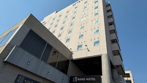 Un edificio de varios pisos con un cartel que dice 'KOKO HOTEL' en la planta baja.
