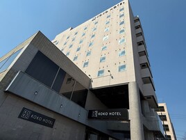 Un edificio de varios pisos con un cartel que dice 'KOKO HOTEL' en la planta baja.