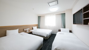 Habitación de hotel con dos camas, un escritorio, una silla, un televisor y una ventana con cortinas.
