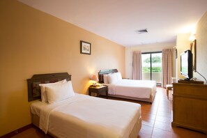 A hotel room with two beds, a television, a dresser, and a window with curtains. - Night Bazaar Place (Chiang Mai)