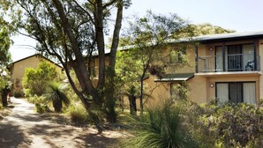 A two-story building with a balcony, surrounded by dense vegetation. - ECU Joondalup Village (Joondalup)