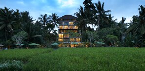 A multi-story building with balconies, surrounded by lush greenery and palm trees. - Plataran Ubud Hotel & Spa (Ubud)