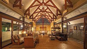 A spacious interior with high ceilings, wooden beams, a fireplace, and a large seating area. - Plataran Ubud Hotel & Spa (Ubud)