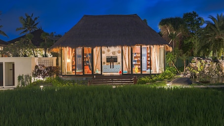 A thatched-roof building with a visible sign reading "aran junior".