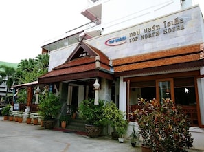 A hotel with a traditional Thai architectural style, featuring a prominent entrance with a tiled roof and a covered porch. - Top North Hotel (Chiang Mai)