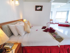 Una camera d'albergo con un letto grande, un telefono sul comodino, una lampada e un quadro appeso al muro.