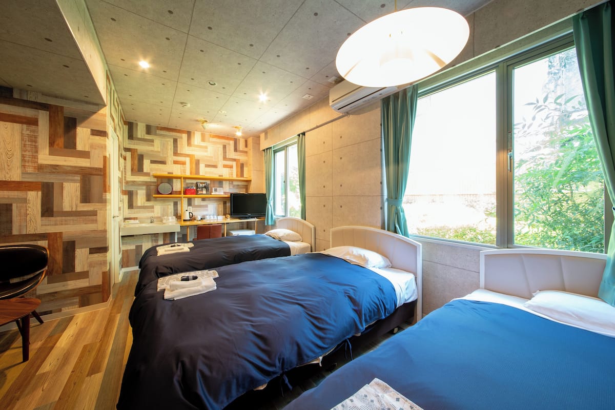 Una habitación de hotel con dos camas, un escritorio, una silla y un televisor.